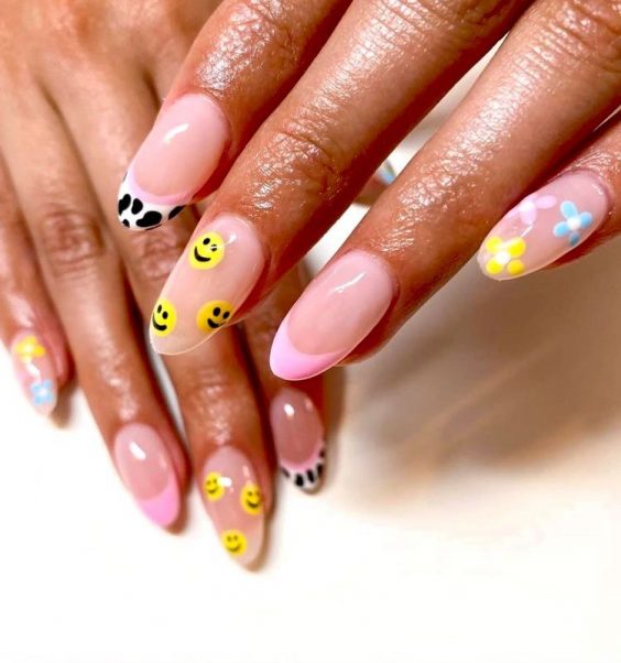 Mismatched nail art trend with smily faces flowers and cow print