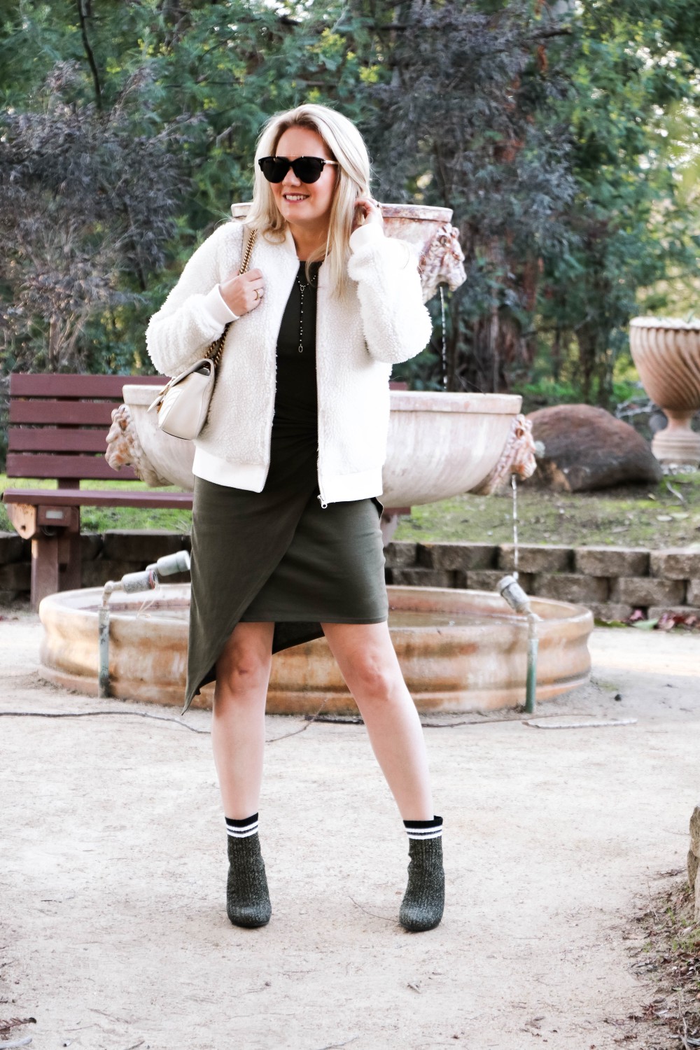 Varsity Style Wearing Fuzzy Bomber Jacket and Stripe Sock Booties | Have Need Want #varsitystyle #bomberjacket #sockbooties #casualstyle #stuartweitzman